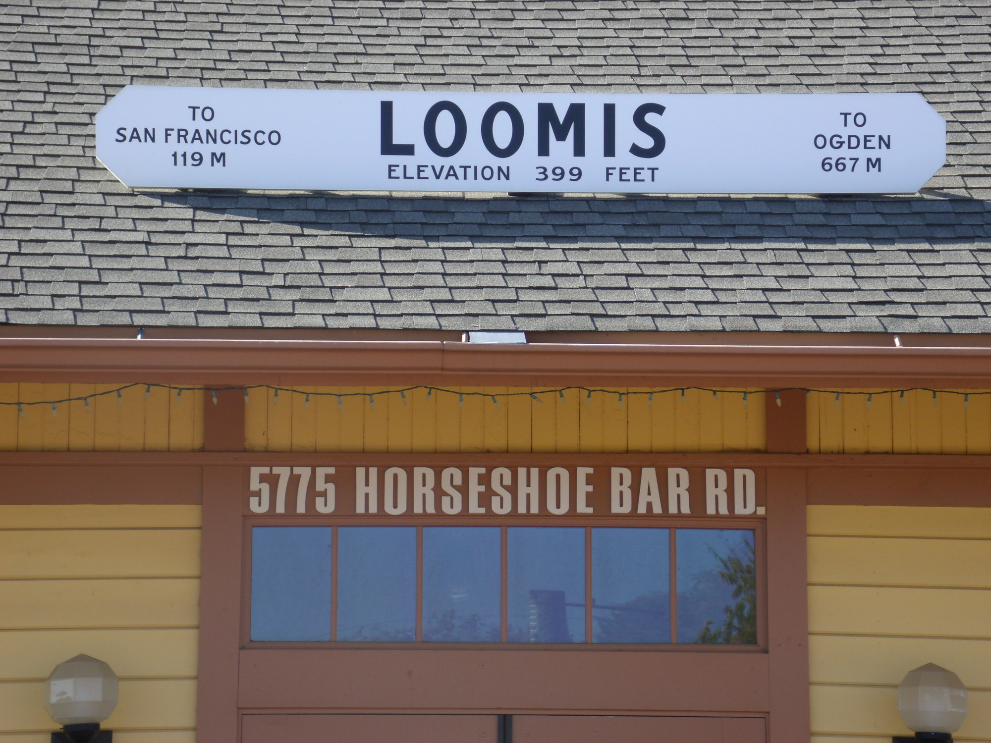 The Loomis train depot sign on the roof above the depot building in Loomis, California